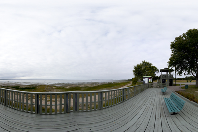 Photographie panoramique montrant l'immensité du lac Saint-Pierre et différents points de vue d'un parc en bordure de ce lac.