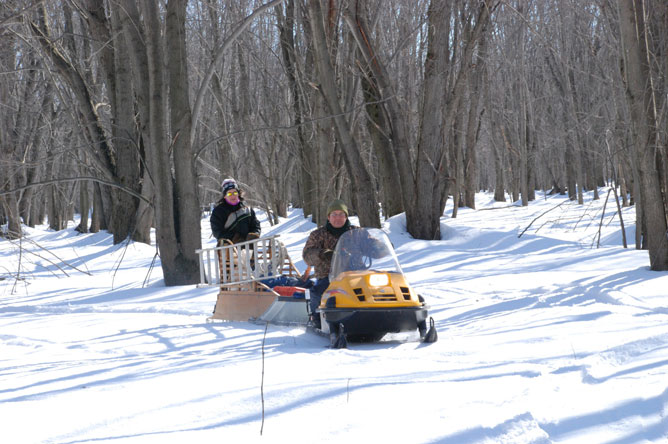 A woman and a man on a snowmobile