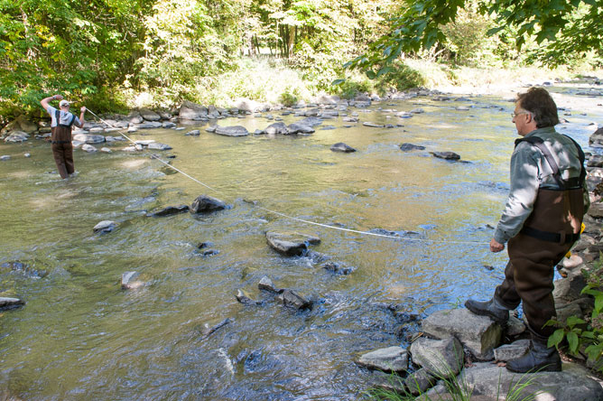 Deux hommes mesurant la largeur de la rivière.