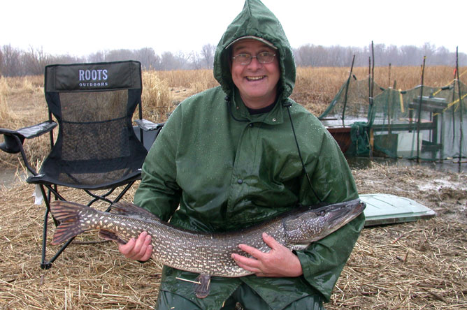 A man holding a large Northern Pike.