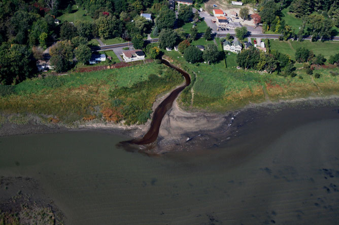 The brown colour of the water can be clearly seen in this aerial photograph of the Saint-Joseph River flowing into the St. Lawrence River at Lanoraie.