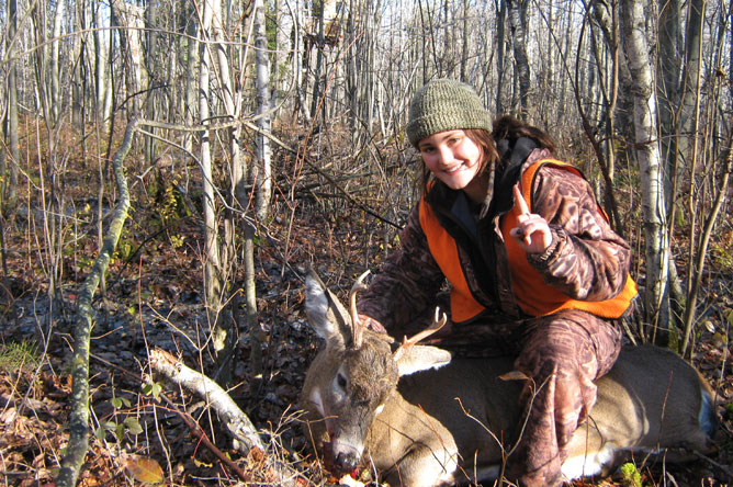 Jeune femme montrant le cerf de Virginie qu'elle vient d'abattre.