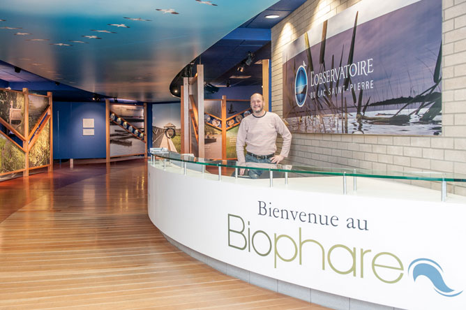  A man standing behind a white desk marked Biophare.