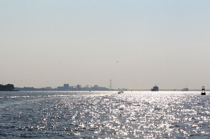 Smokestacks of Rio Tinto Fer et Titane silhouetted against the horizon, seen from the St. Lawrence.