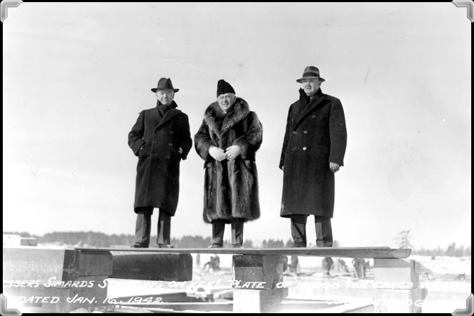 Black and white photograph of Ludger, Joseph and Édouard Simard standing on keel plate of 10 000 ton cargo.
