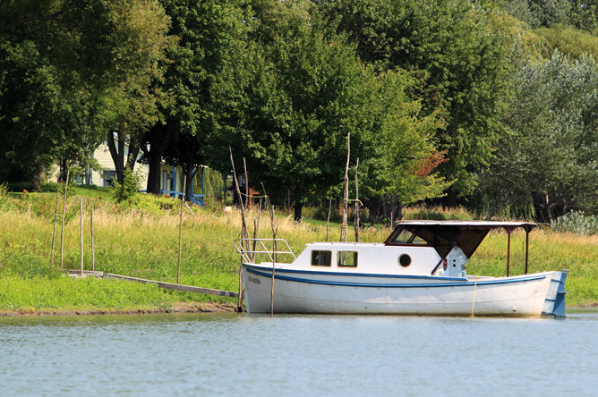 Small blue and white boat moored at a dock on an island in the Lake Saint-Pierre archipelago.