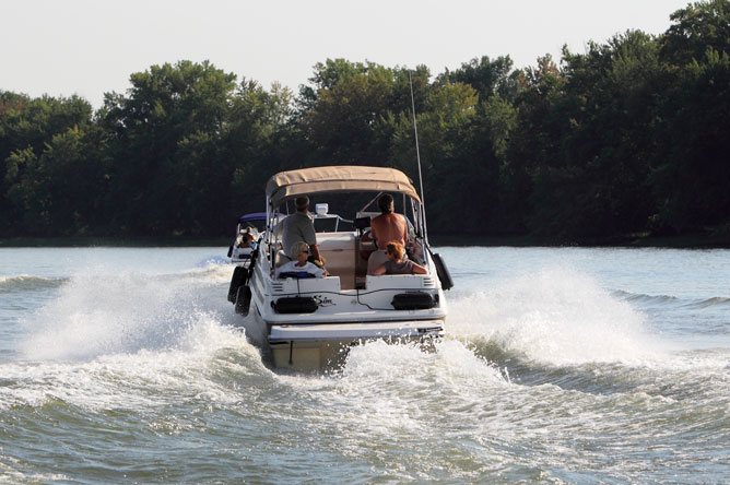 Two pleasure boats leaving large waves.