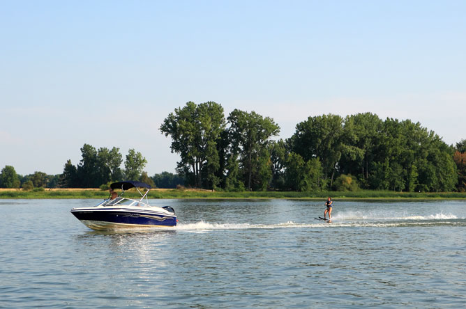 Pleasure craft towing a woman on water skis.