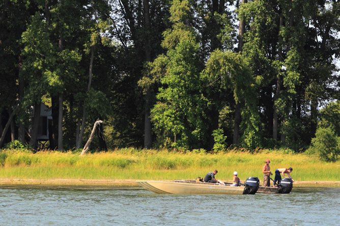 Four fishermen in two boats in front of Île Plate