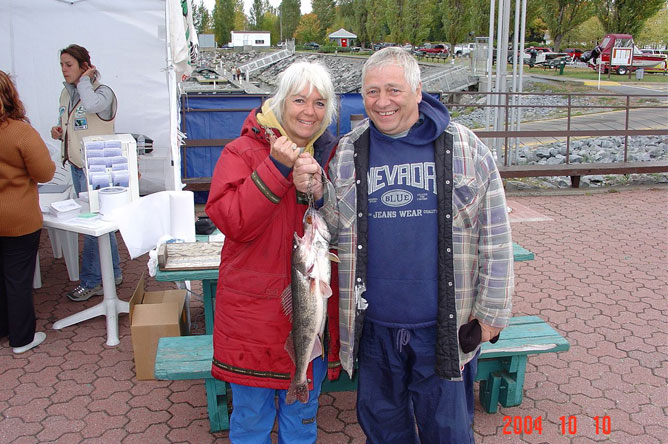 A man and a woman show off the two Walleyes they have landed.