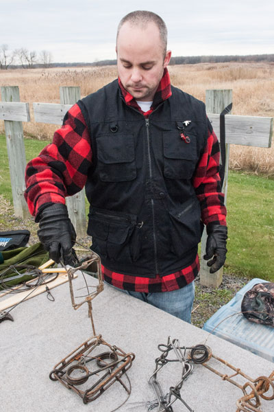 Un homme montrant les pièges qu'il utilise.