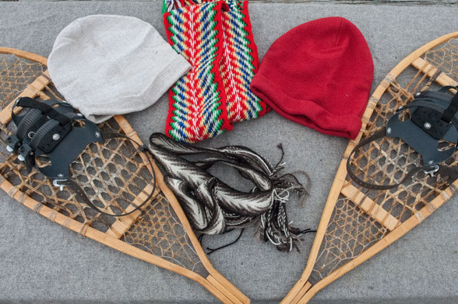 Snowshoes, hats and arrowhead sashes displayed on a table.