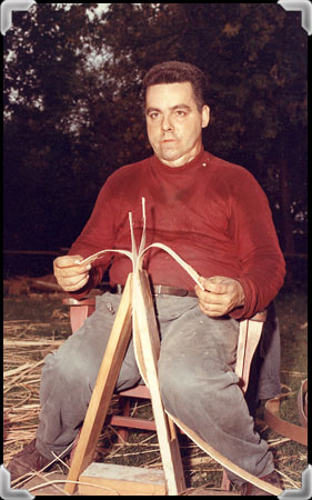 A man detaches splints from a black ash trunk; taken in the 1960s.