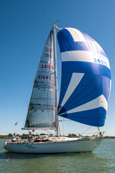 Two people aboard a sailboat on the St. Lawrence