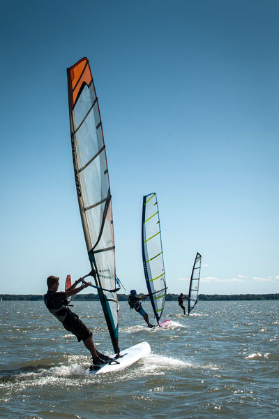 Trois personnes sur leurs planches à voile au lac Saint-Pierre