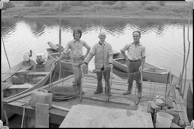 Fishermen holding a hoop net on the dock at Sainte-Anne-de-Sorel.
