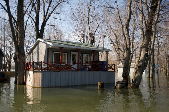 Chalet brun pâle sur pilotis lors d'une inondation printanière