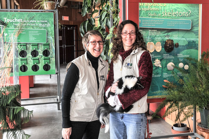 Caroline Labarre holding a Striped Skunk, next to Carole Bellerose.