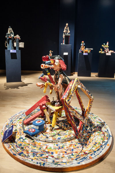 Vue rapprochée d'une sculpture en bois montrant un personnage aux cheveux rouges