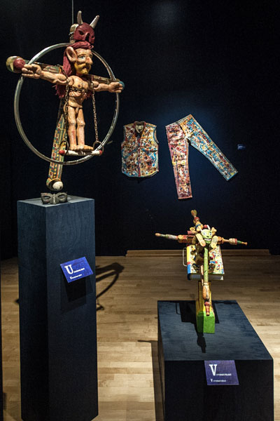 Vue rapprochée de deux sculptures en bois montrant des personnages crucifiés portant des cornes sur la tête