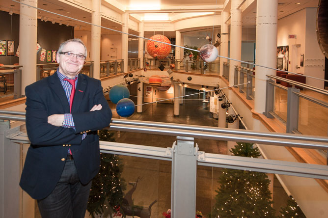 Yvon Noël au deuxième étage du musée devant les accessoires multicolores du Grand hall