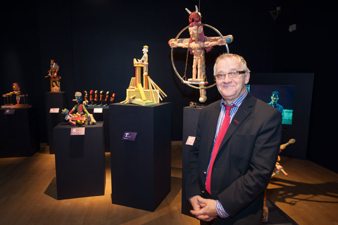 Yvon Noël devant les sculptures en bois des personnages fantaisistes au Musée québécois de culture populaire